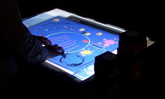 A user simultaneously free-drawing with multiple fingers on the interacTable’s surface